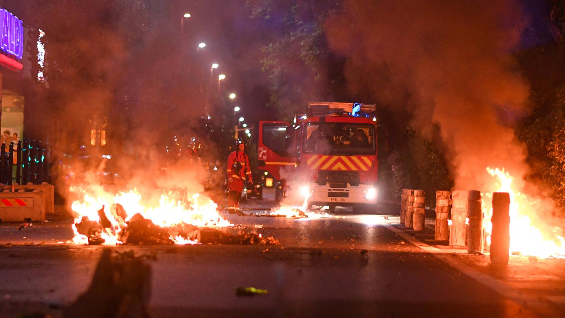 Feuerwehrleute bei Nacht bei einem Brand auf einer Straße in Frankreich 