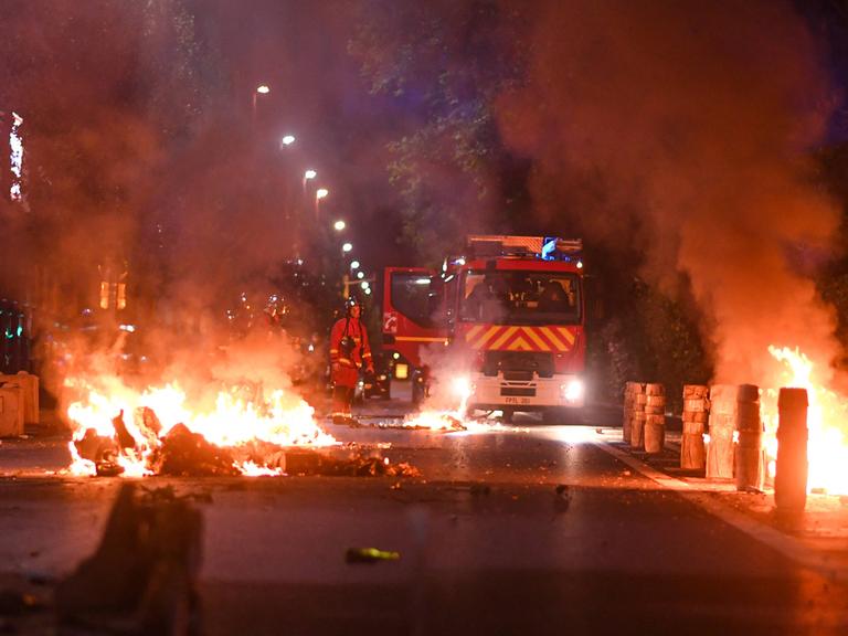 Feuerwehrleute bei Nacht bei einem Brand auf einer Straße in Frankreich 