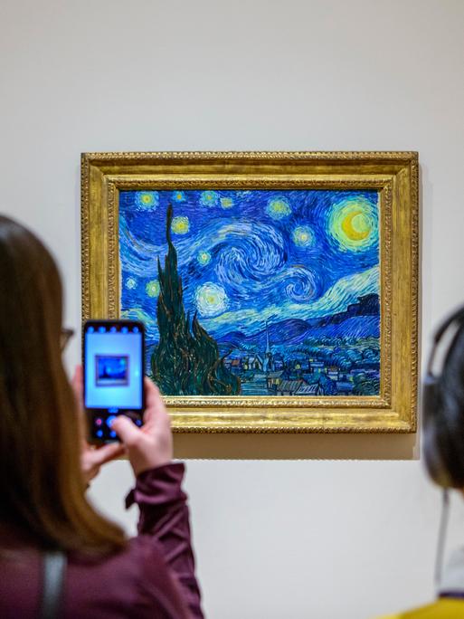 Besucher vor dem Gemälde Sternennacht von Vincent van Gogh, Museum of Modern Art in New York City, USA.