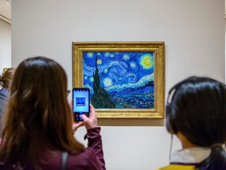 Besucher vor dem Gemälde Sternennacht von Vincent van Gogh, Museum of Modern Art in New York City, USA.