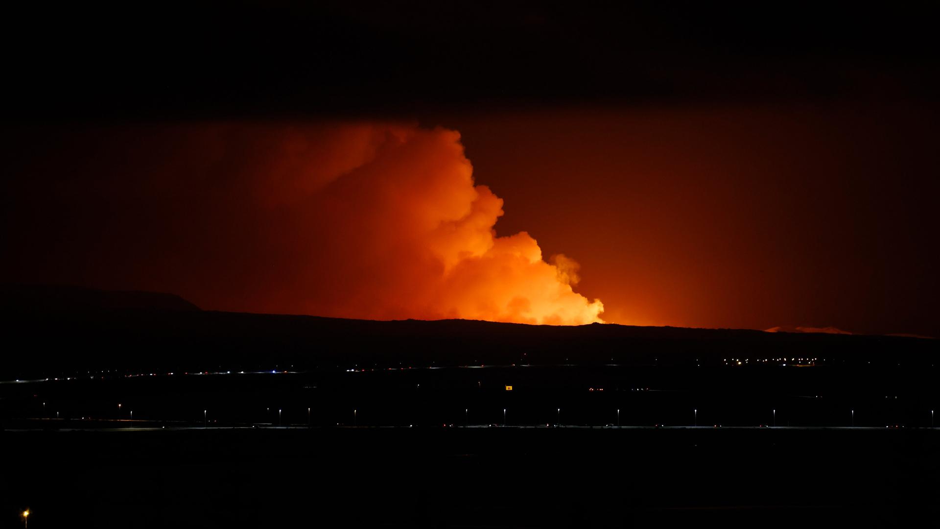 Reykjavik: Der Nachthimmel wird durch den Ausbruch eines Vulkans auf der Halbinsel Reykjanes im Südwesten Islands erhellt, gesehen von der Hauptstadt Reykjavik aus.