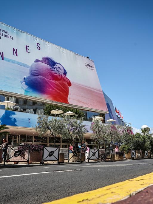 Ein Plakat der Cannes-Filmfeststpiele hängt an einem Gebäude an einer Straße in Cannes.