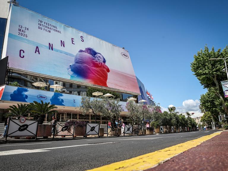 Ein Plakat der Cannes-Filmfeststpiele hängt an einem Gebäude an einer Straße in Cannes.
