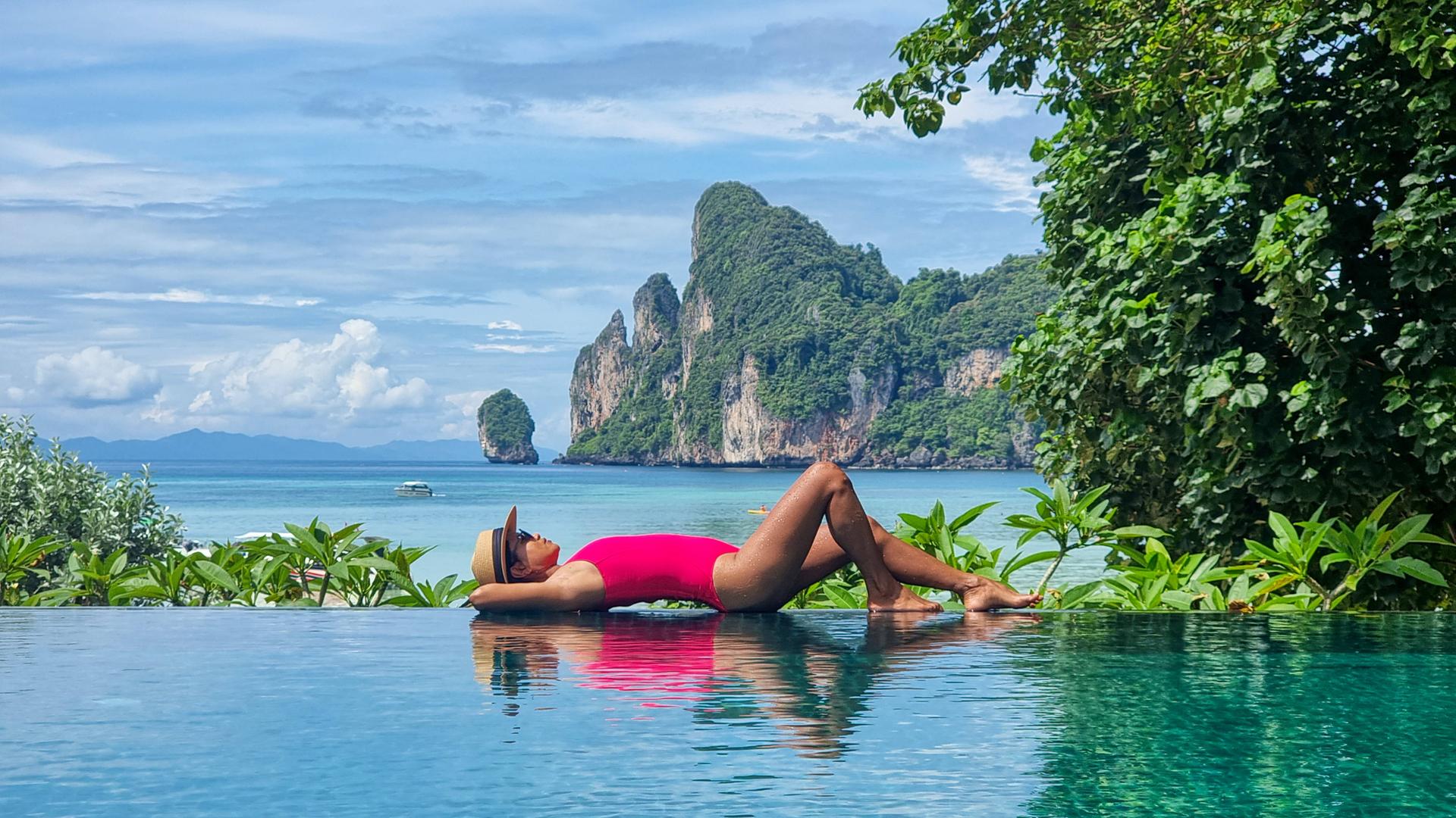 Eine Frau im Badeanzug während eines Urlaubs im Infinity Pool in Thailand.