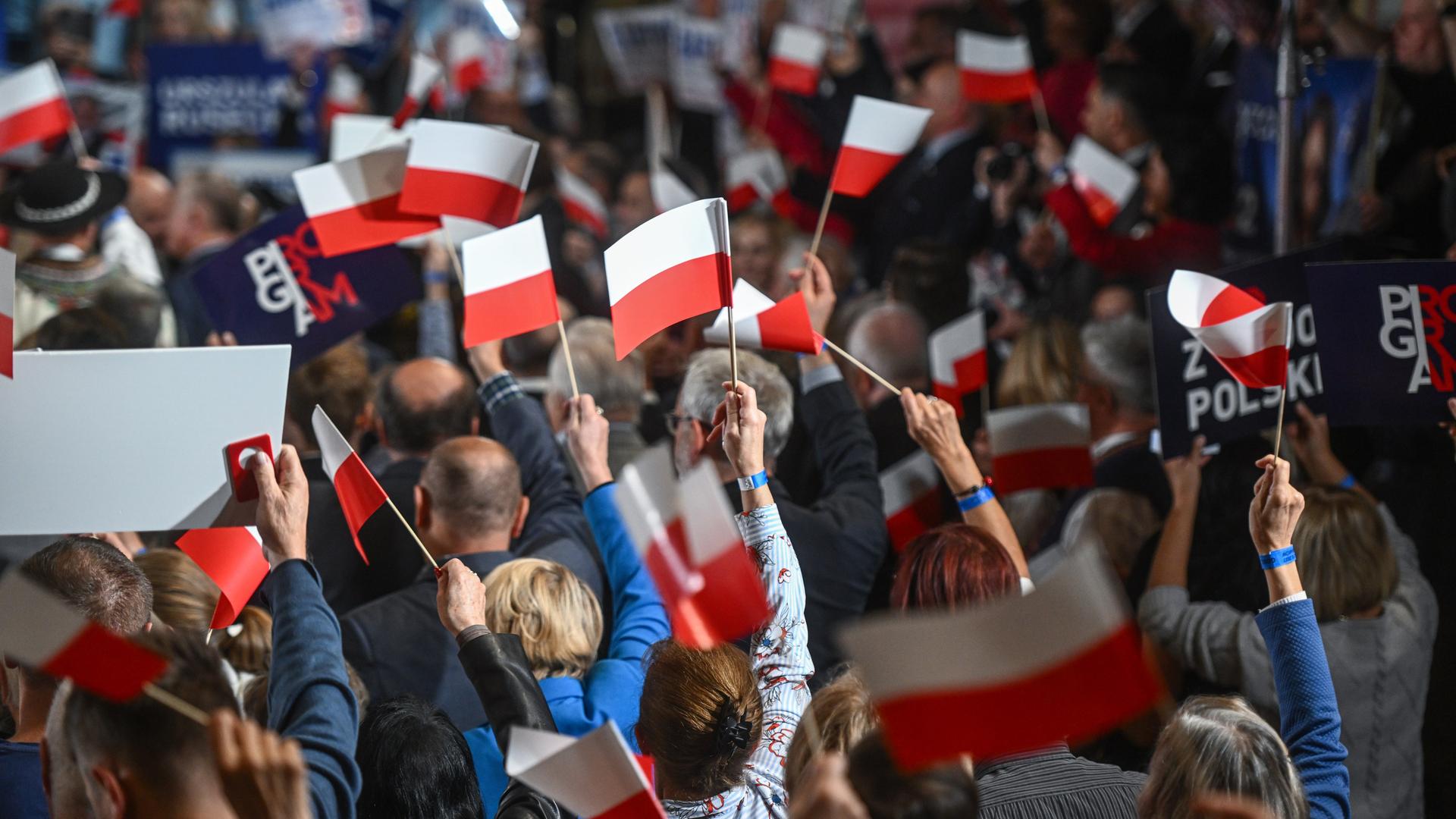 Anhänger der amtierenden PiS-Partei schwenken rot-weiße polnische Fahnen.