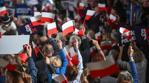 Polen vor der Wahl: Anhänger der amtierenden PiS-Partei schwenken rot-weiße polnische Fahnen. 