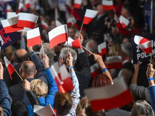 Polen vor der Wahl: Anhänger der amtierenden PiS-Partei schwenken rot-weiße polnische Fahnen. 