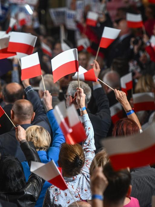 Polen vor der Wahl: Anhänger der amtierenden PiS-Partei schwenken rot-weiße polnische Fahnen. 
