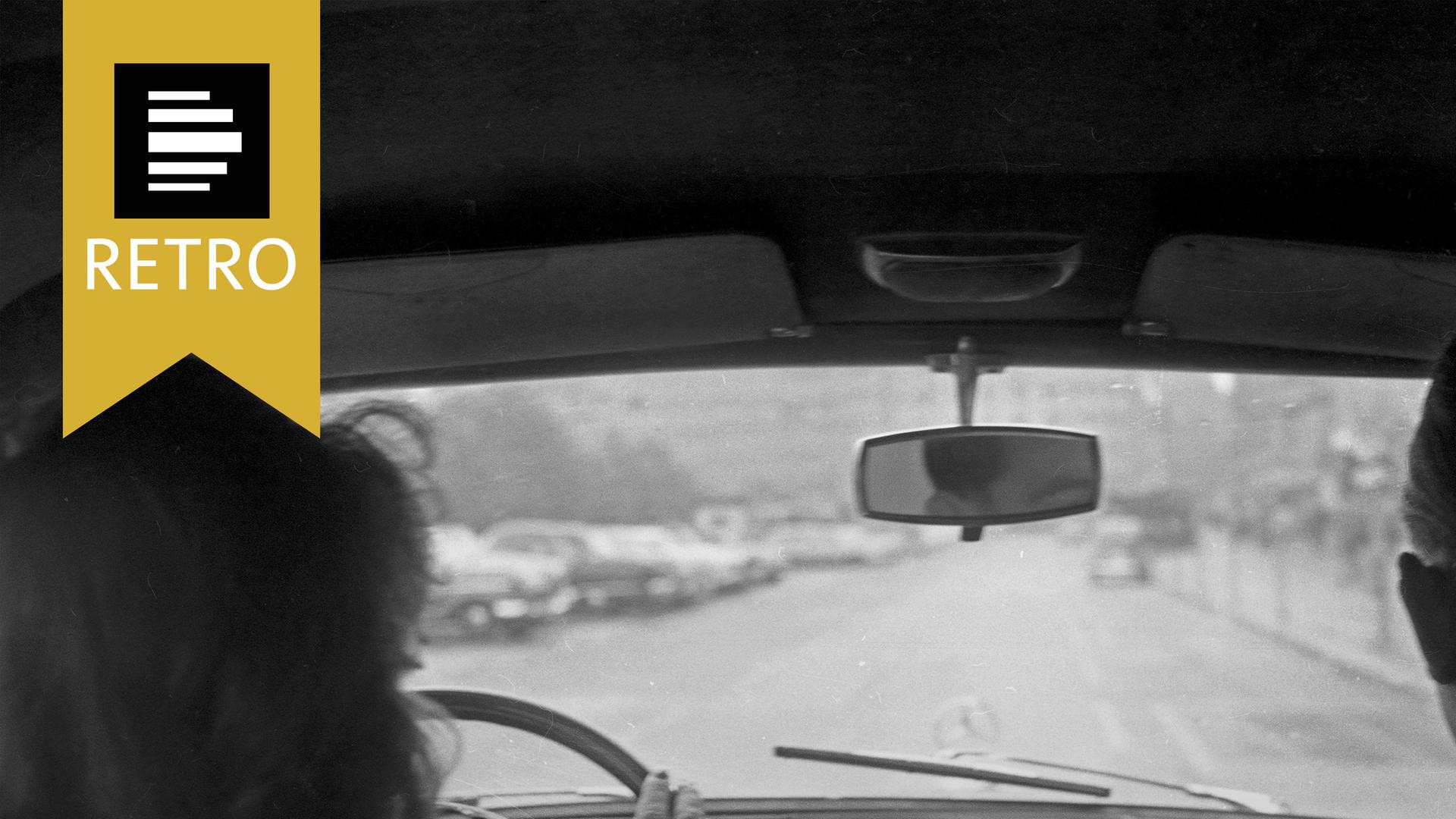 Eine Frau sitzt hinter einem Auto-Lenkrad.