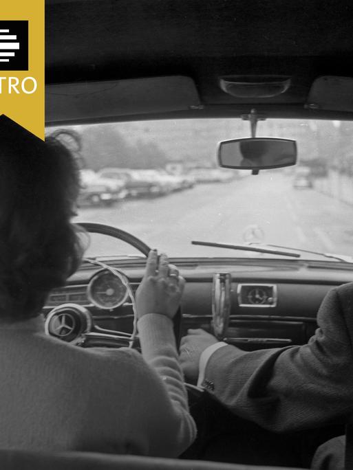 Eine Frau sitzt hinter einem Auto-Lenkrad.