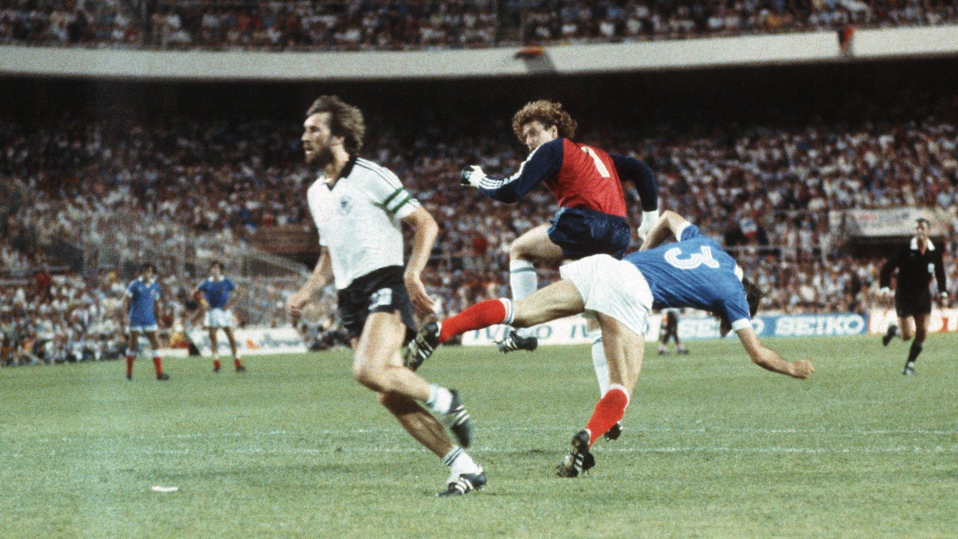 Harald "Toni" Schumacher (2.v.l.), bei der WM 1982 deutscher Nationaltorhüter, streckt beim Hinauslaufen Frankreichs Patrick Battiston (3.v.l.) brutal nieder.