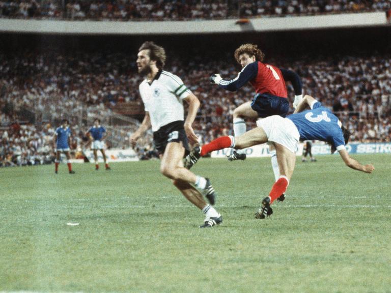 Harald "Toni" Schumacher (2.v.l.), bei der WM 1982 deutscher Nationaltorhüter, streckt beim Hinauslaufen Frankreichs Patrick Battiston (3.v.l.) brutal nieder.