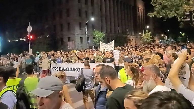Menschen ziehen mit Plakaten durch Serbiens Hauptstadt Belgrad.