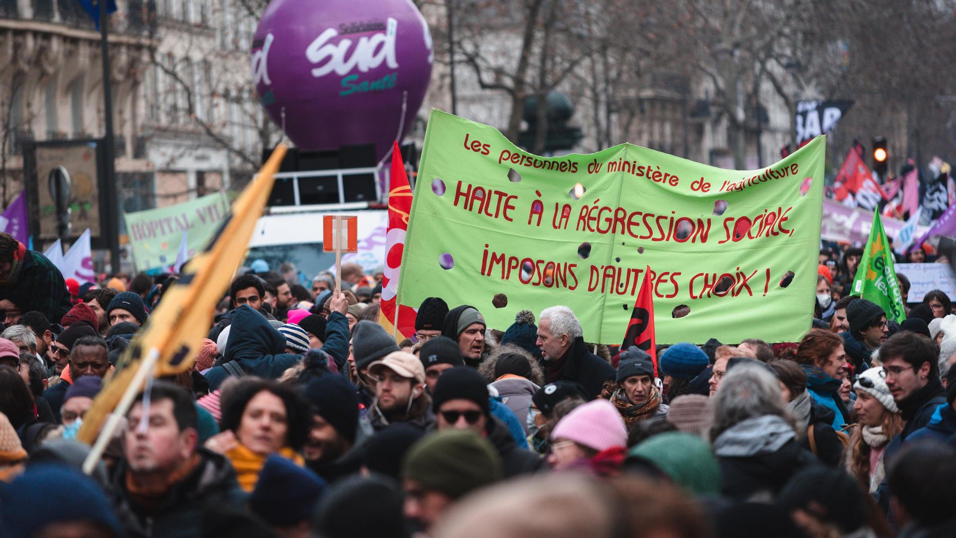 Demonstrators hold a banner with the slogan 'Stop social regression, let's impose other choices!' during the demonstration which brought together tens of thousands of people who take part in a demonstration in Paris on January 19, 2023, as workers go on strike against the pension reform project presented by the French government to increase the legal retirement age from 62 to 64 years. Demonstrators hold a banner with the slogan 'Stop social regression, let's impose other choices!' during the demonstration which brought together tens of thousands of people who take part in a demonstration in Paris on January 19, 2023, as workers go on strike against the pension reform project presented by the French government to increase the legal retirement age from 62 to 64 years.