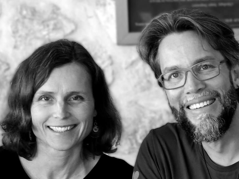 Anna und Patrick Hemminger sitzen an einem Esstisch und lächeln.