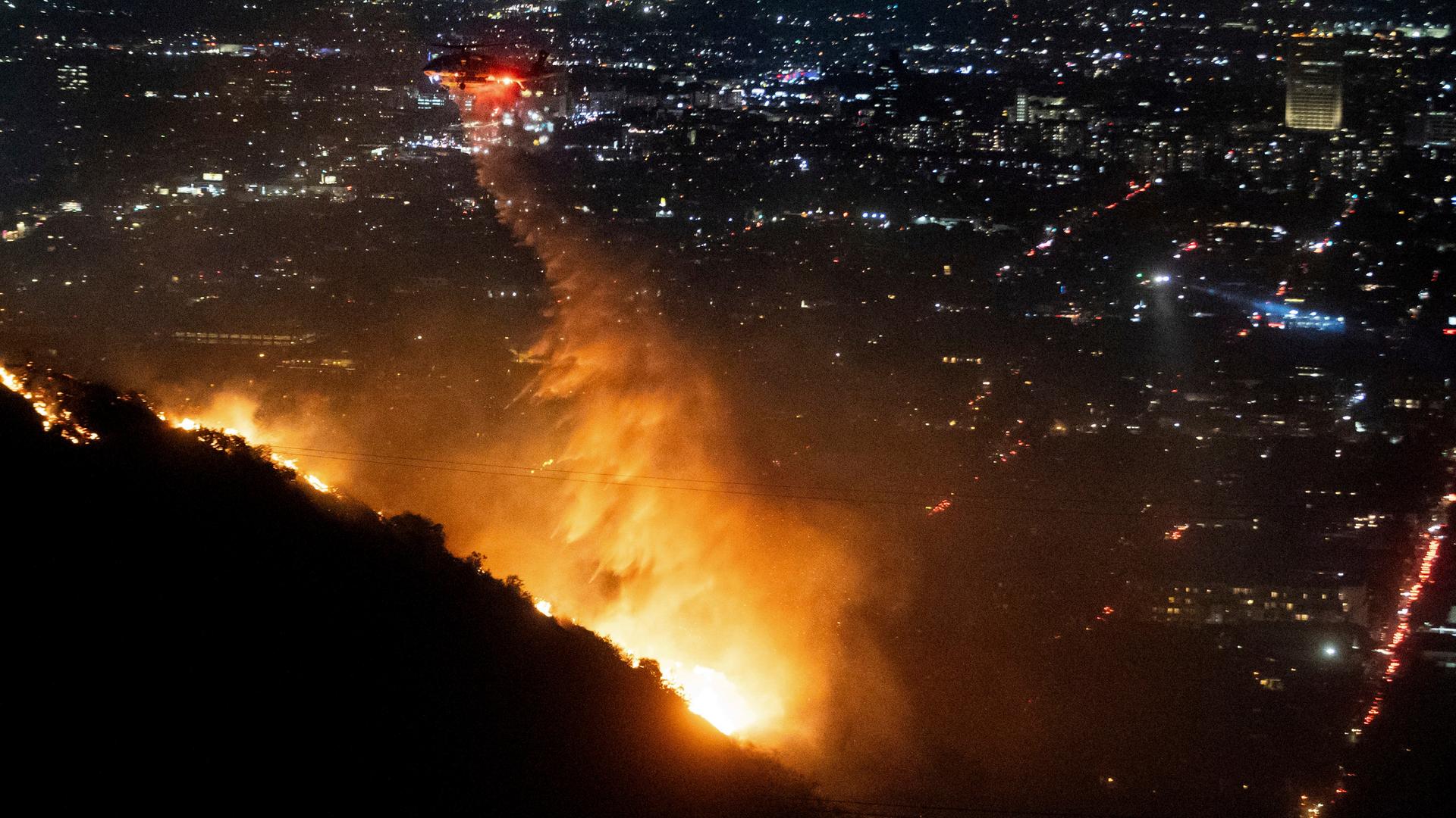 Los Angeles: Ein Hubschrauber wirft Wasser auf das brennende Sunset Fire in den Hollywood Hills. 