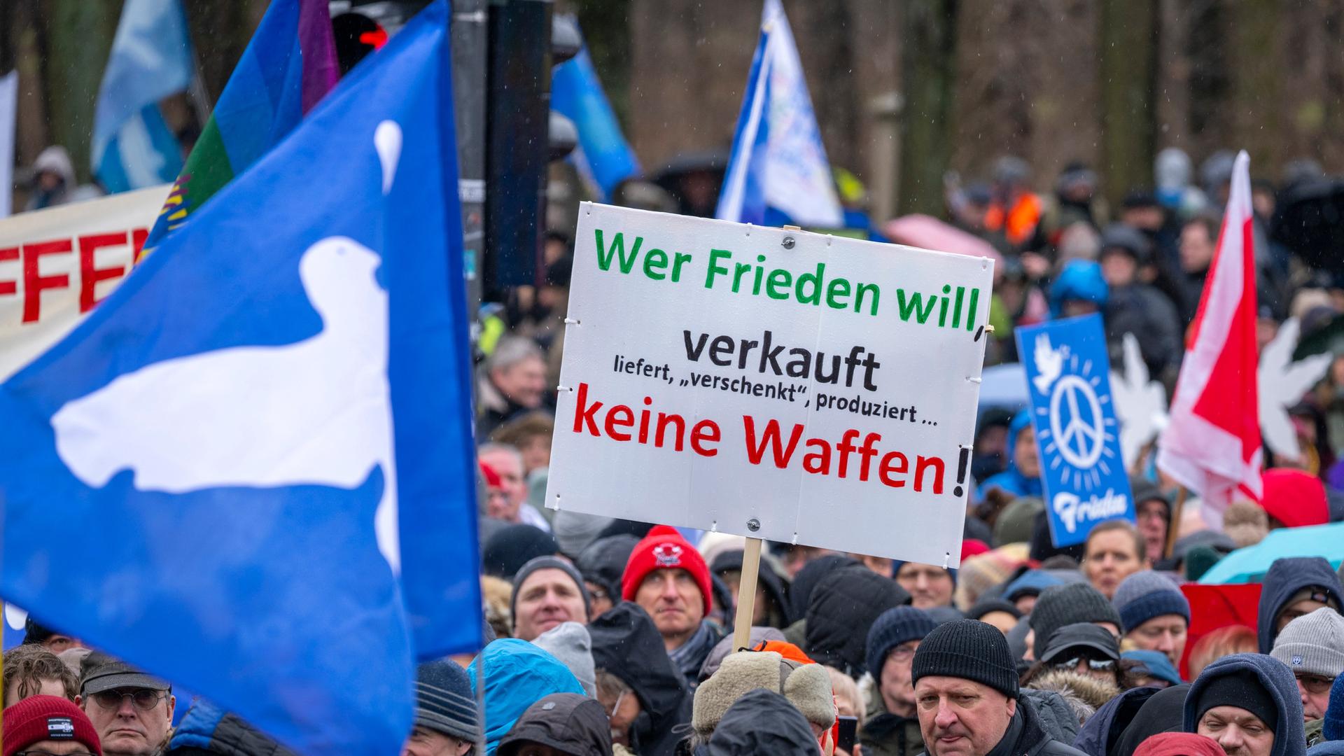 Ein Teilnehmer der Demonstration in Berlin hält ein Schild mit der Aufschrift "Wer Frieden will verkauft, liefert, verschenkt, produziert keine Waffen." Ein Teilnehmer der Demonstration in Berlin hält ein Schild mit der Aufschrift "Wer Frieden will verkauft, liefert, verschenkt, produziert keine Waffen."