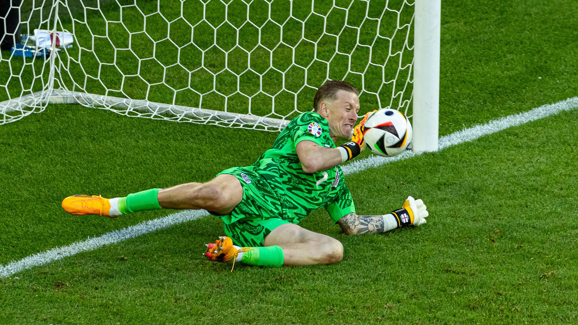 Englands Torhüter Jordan Pickford pariert den ersten Elfmeter des Elfmeterschießens während des UEFA Euro 2024-Viertelfinalspiels zwischen England und der Schweiz. Das Spiel endete 1:1 nach Verlängerung, England gewann 5:3 im Elfmeterschießen.