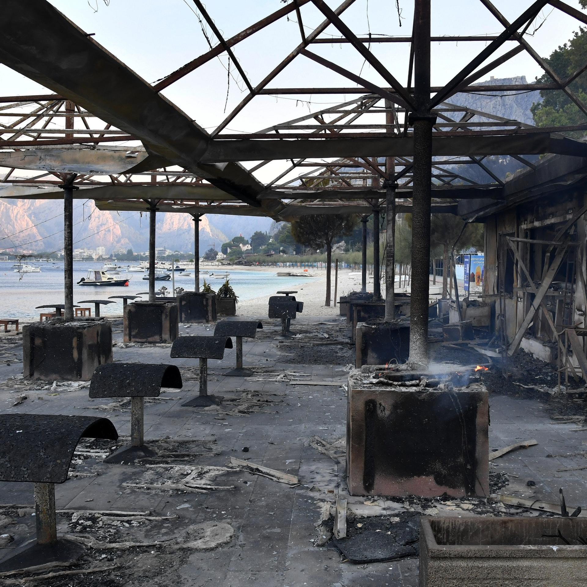 Blick auf eine Strandbar nach einem Waldbrand an der Adriaküste in der Nähe von Omis im Süden Kroatiens