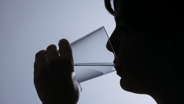 Symbolfoto: Silhouette einer Frau, die ein Glas Leitungswasser trinkt. Symbolfoto: Silhouette einer Frau, die ein Glas Leitungswasser trinkt.
