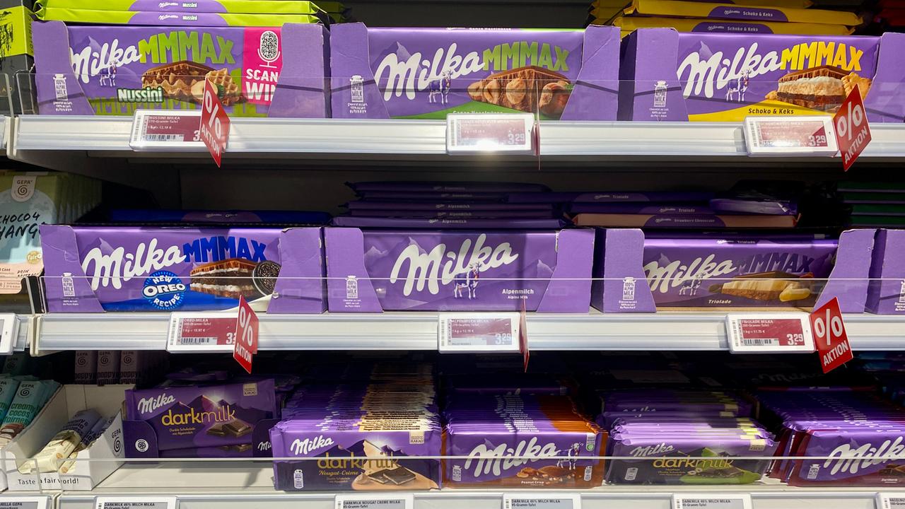 Mehrere unterschiedliche Packungsgrößen der Tafelschokolade "Milka" sind in einem Supermarkt in Regalen. 