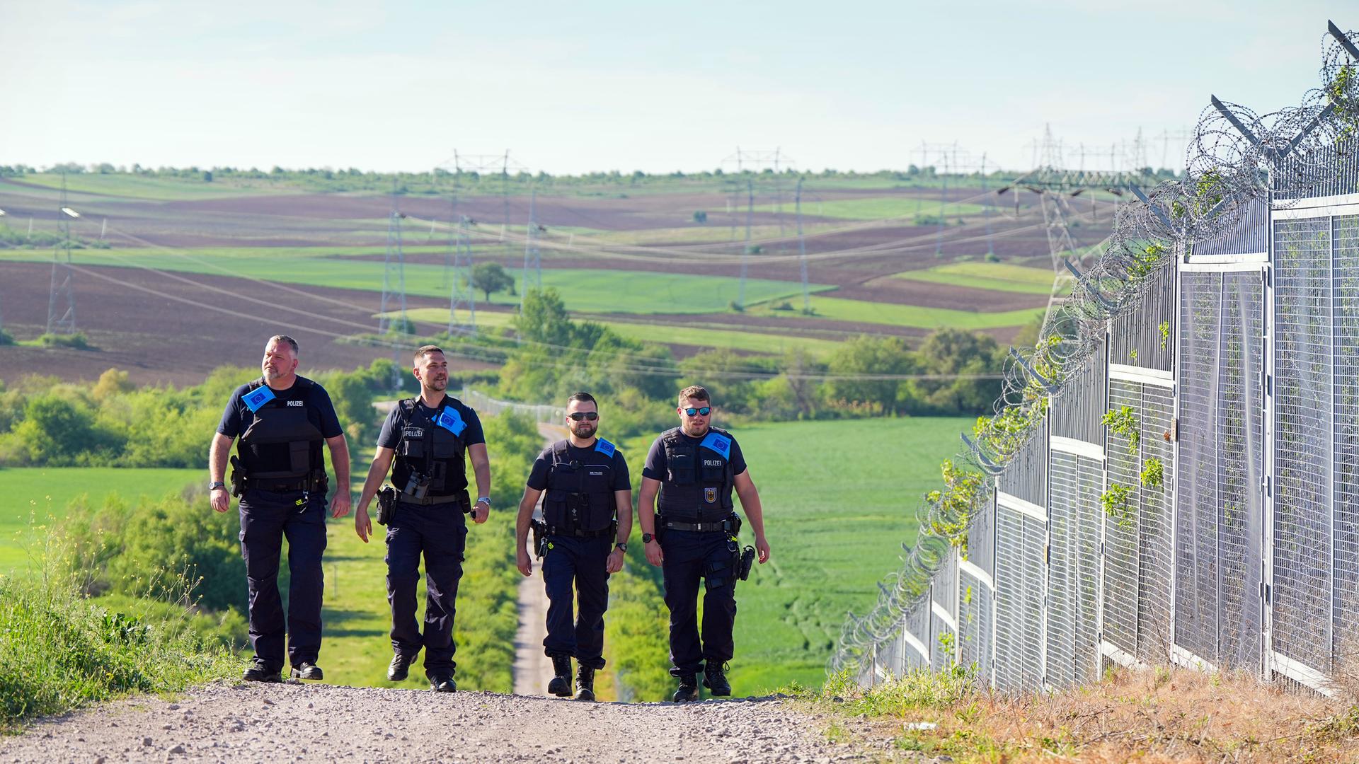 Vier deutsche Beamte der Bundespolizei im Frontex-Einsatz gehen an der türkisch-bulgarischen "Grünen Grenze" in Swilengrad entlang. Neben ihnen sind hohe Zäune mit Natodraht. Vier deutsche Beamte der Bundespolizei im Frontex-Einsatz gehen an der türkisch-bulgarischen "Grünen Grenze" in Swilengrad entlang. Neben ihnen sind hohe Zäune mit Natodraht.