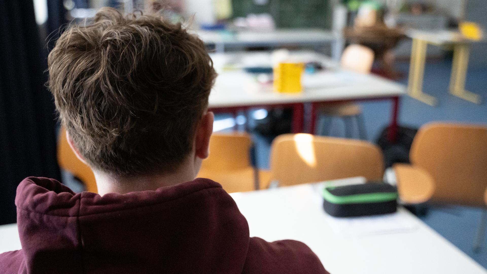 Ein Schüler sitzt an einem Tisch im Klassenzimmer einer Schule. Ein Schüler sitzt an einem Tisch im Klassenzimmer einer Schule.