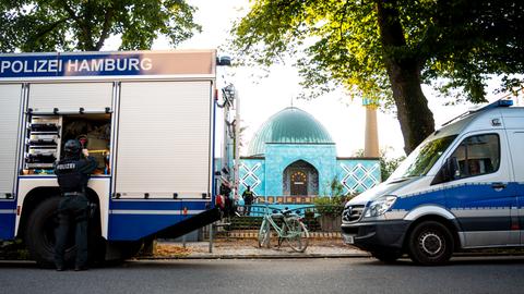Zwei Fahrzeuge der Polizei stehen vor der Blauen Moschee in Hamburg.