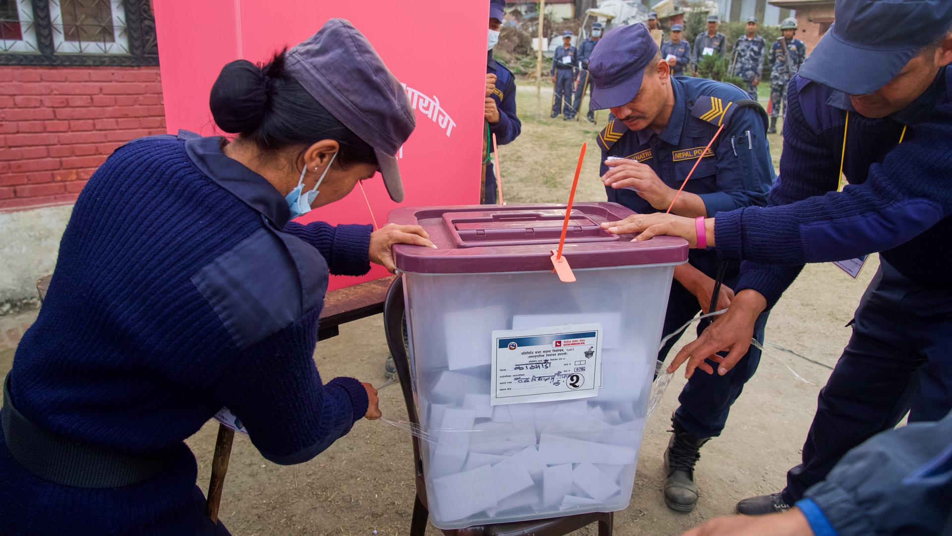 Polizisten schließen eine Wahlurne am Ende der Stimmabgabe während der Parlamentswahlen in Kathmandu, Nepal.
