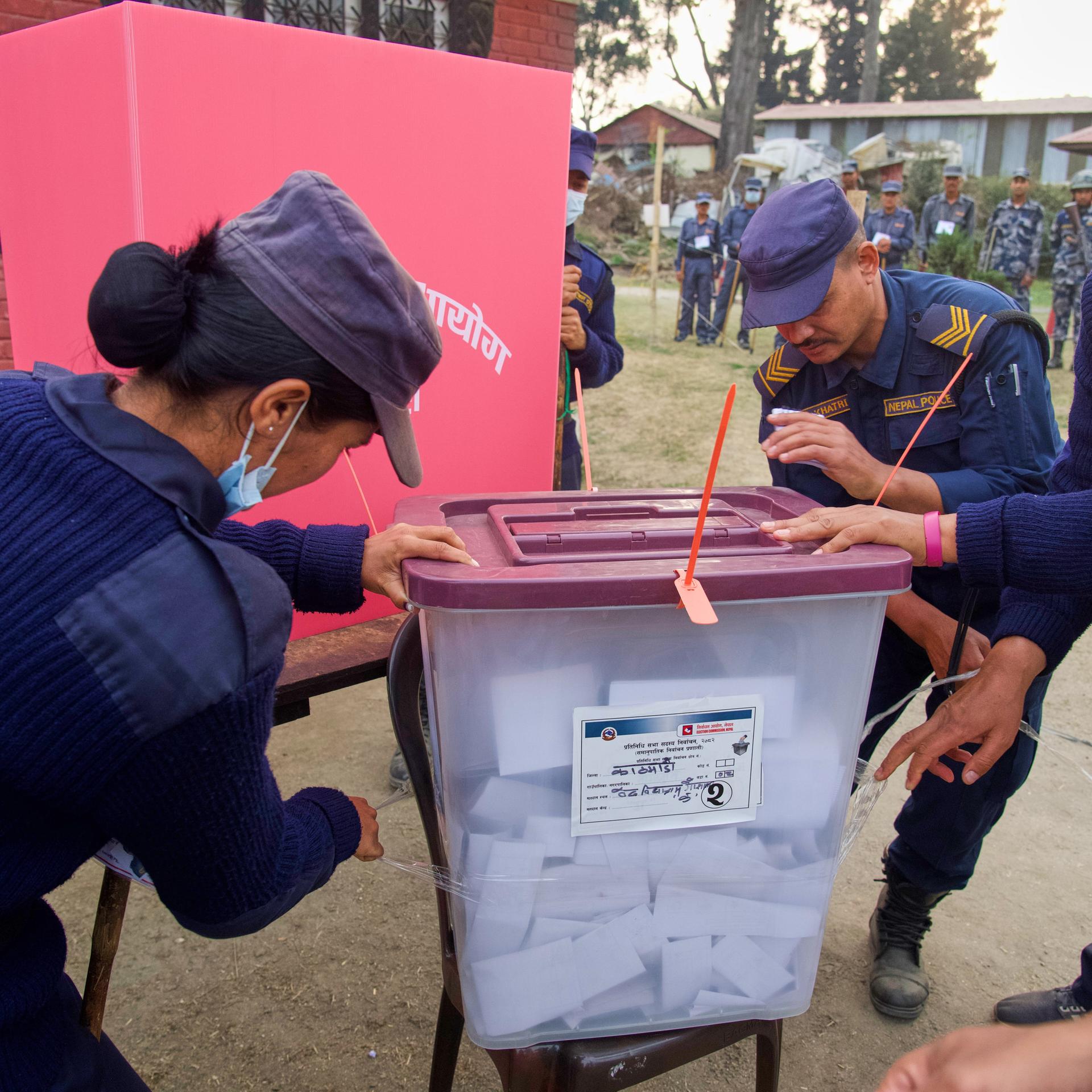 Polizisten schließen eine Wahlurne am Ende der Stimmabgabe während der Parlamentswahlen in Kathmandu, Nepal.