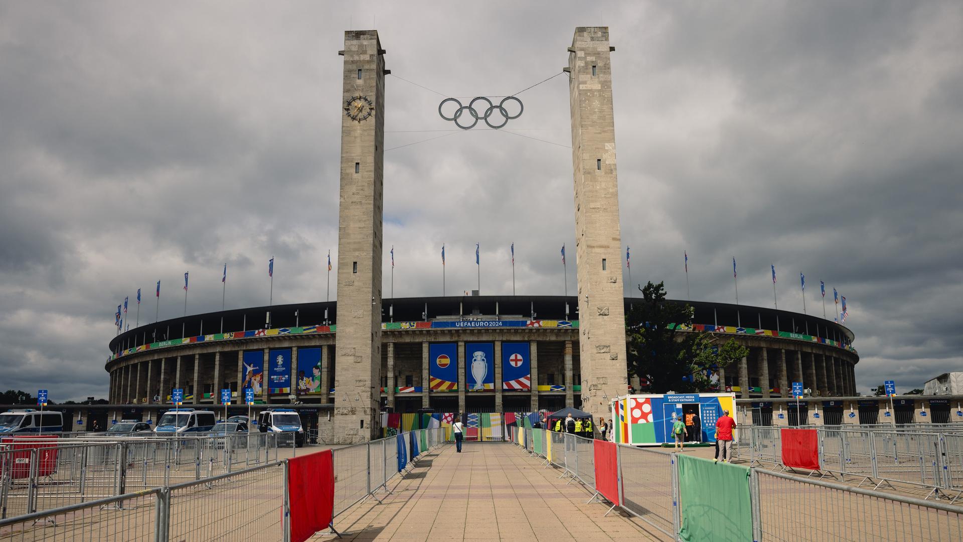 Das Olympiastadion in Berlin von Außen vor grau-bewölktem Himmel.
