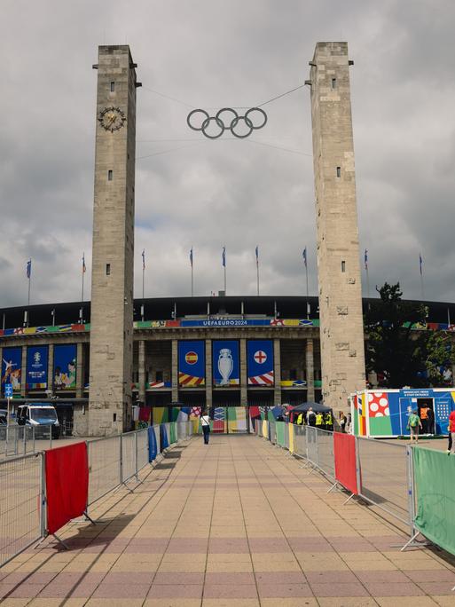 Das Olympiastadion in Berlin von Außen vor grau-bewölktem Himmel.