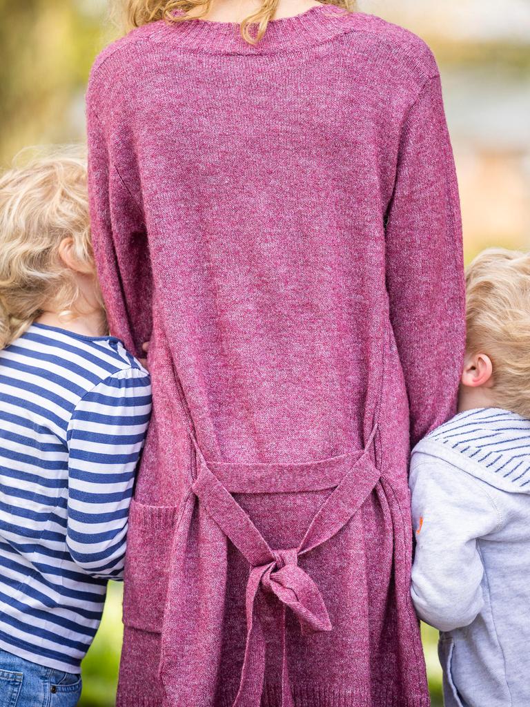 Zu sehen ist eine Frau von hinten, an die sich jeweils ein Junge und ein Mädchen anschmiegen. Vermutlich Sohn und Tochter. Zu sehen ist eine Frau von hinten, an die sich jeweils ein Junge und ein Mädchen anschmiegen. Vermutlich Sohn und Tochter.