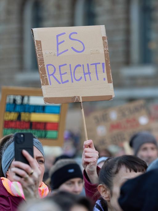 Eine Teilnehmerin hält auf dem Rathausmarkt ein Plakat während der Demonstration gegen sexualisierte Gewalt gegen Frauen hoch.