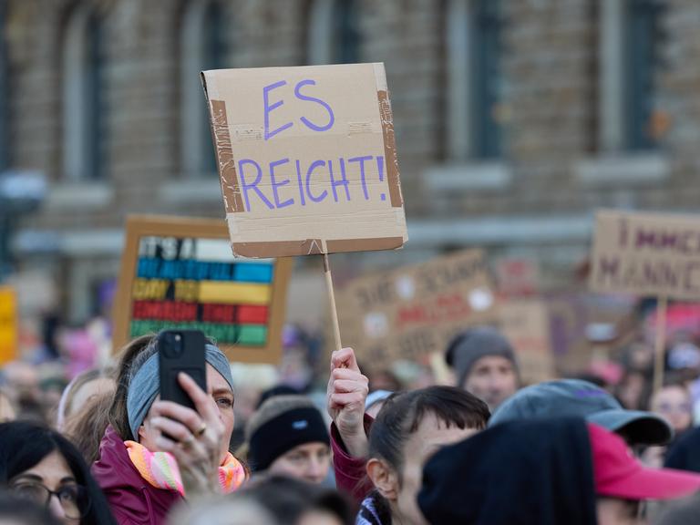 Eine Teilnehmerin hält auf dem Rathausmarkt ein Plakat während der Demonstration gegen sexualisierte Gewalt gegen Frauen hoch.