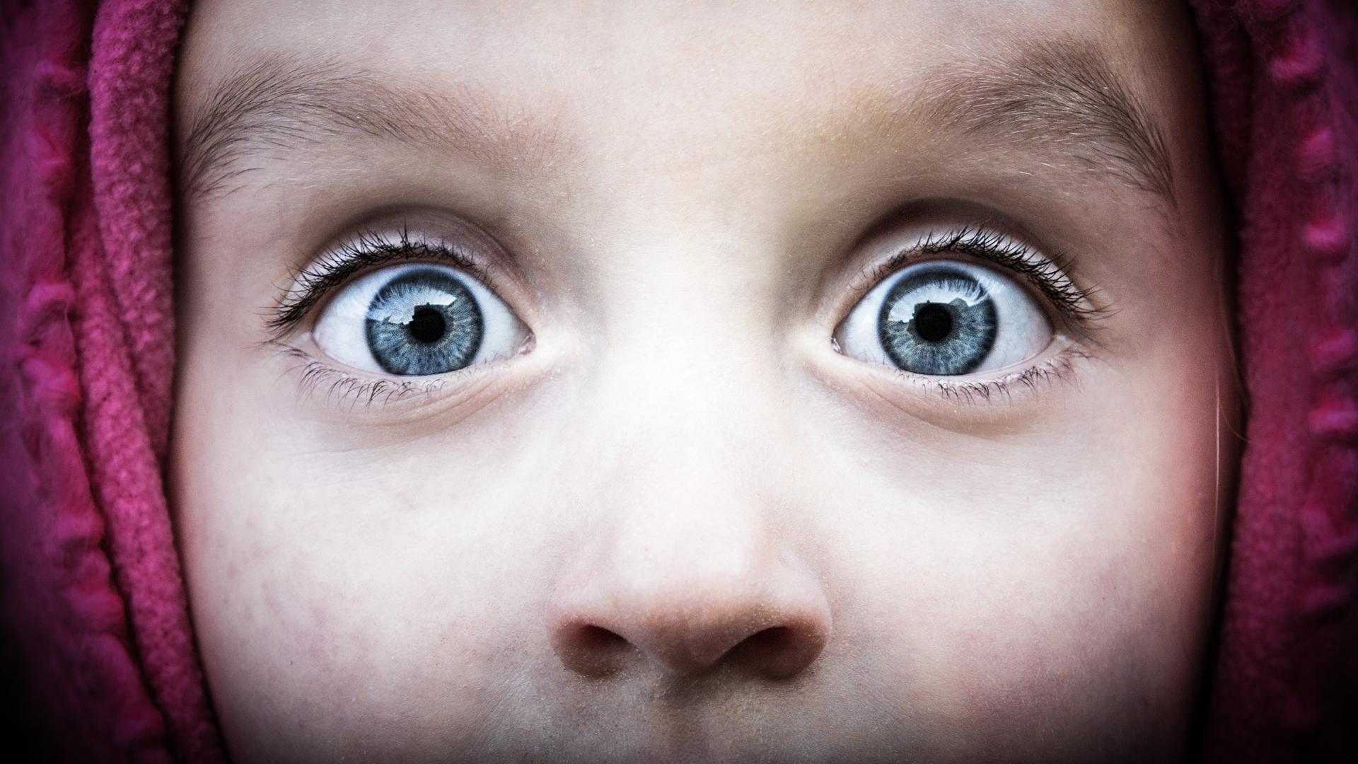 Aufnahme der Augenpartie eines Kindes mit weit aufgerissenen Augen, die grosses Erstaunenausdrücken.