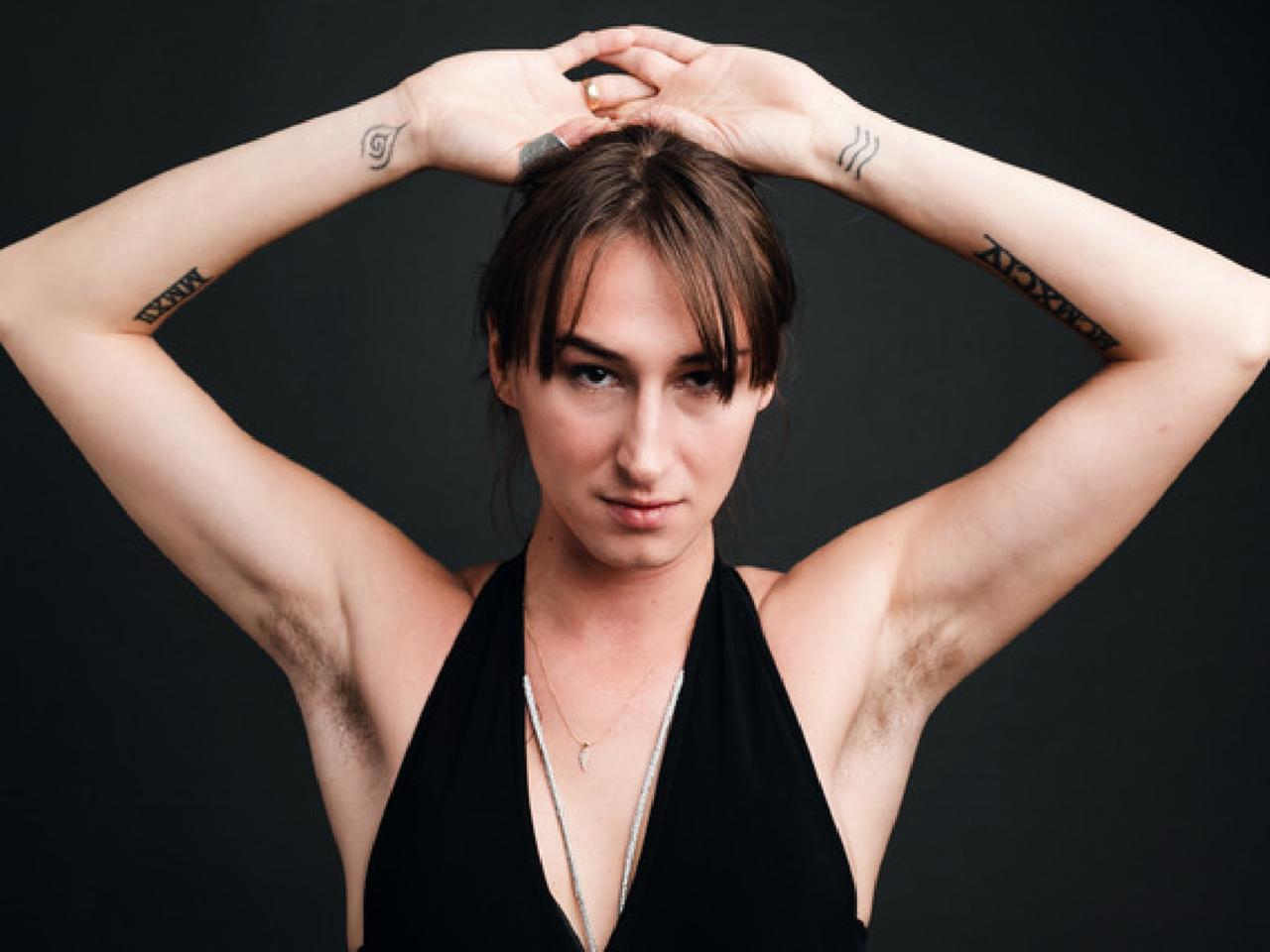 Porträtaufnahme der Schauspielerin Kristina Maca, die die Arme über den Kopf hebt.