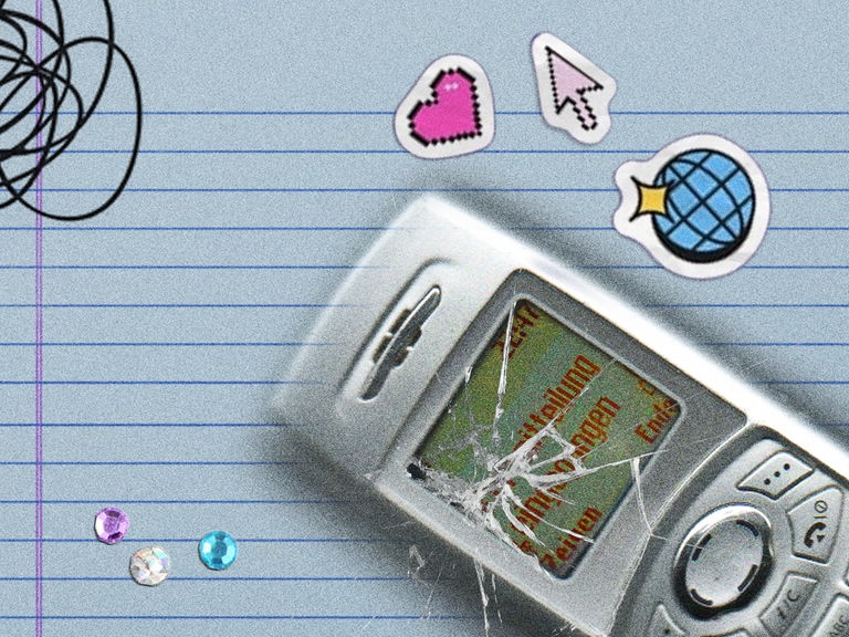 Ein Handy mit zerbrochenem Display liegt auf einem linierten Blatt Papier, daneben ein Herzchen, ein Mauscursor und Glitzersteine