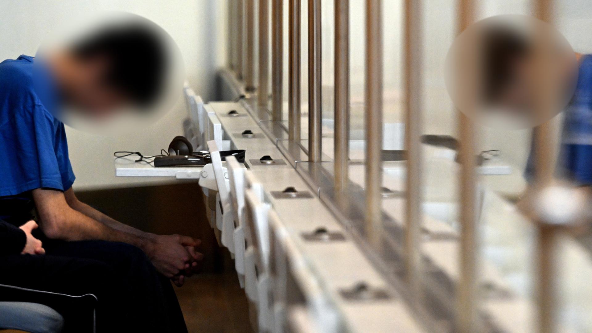 Düsseldorf: Der Angeklagte im Gerichtssaal der Oberlandesgerichts. Er sitzt hinter Gitterstäben, hat den Kopf gesenkt, sein Gesicht ist verpixelt.