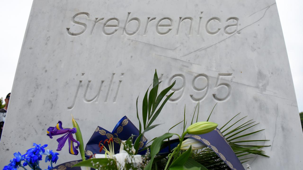 Blick auf einen mit Blumen geschmückten Gedenkstein für die Opfer des Völkermordes von Srebrenica.