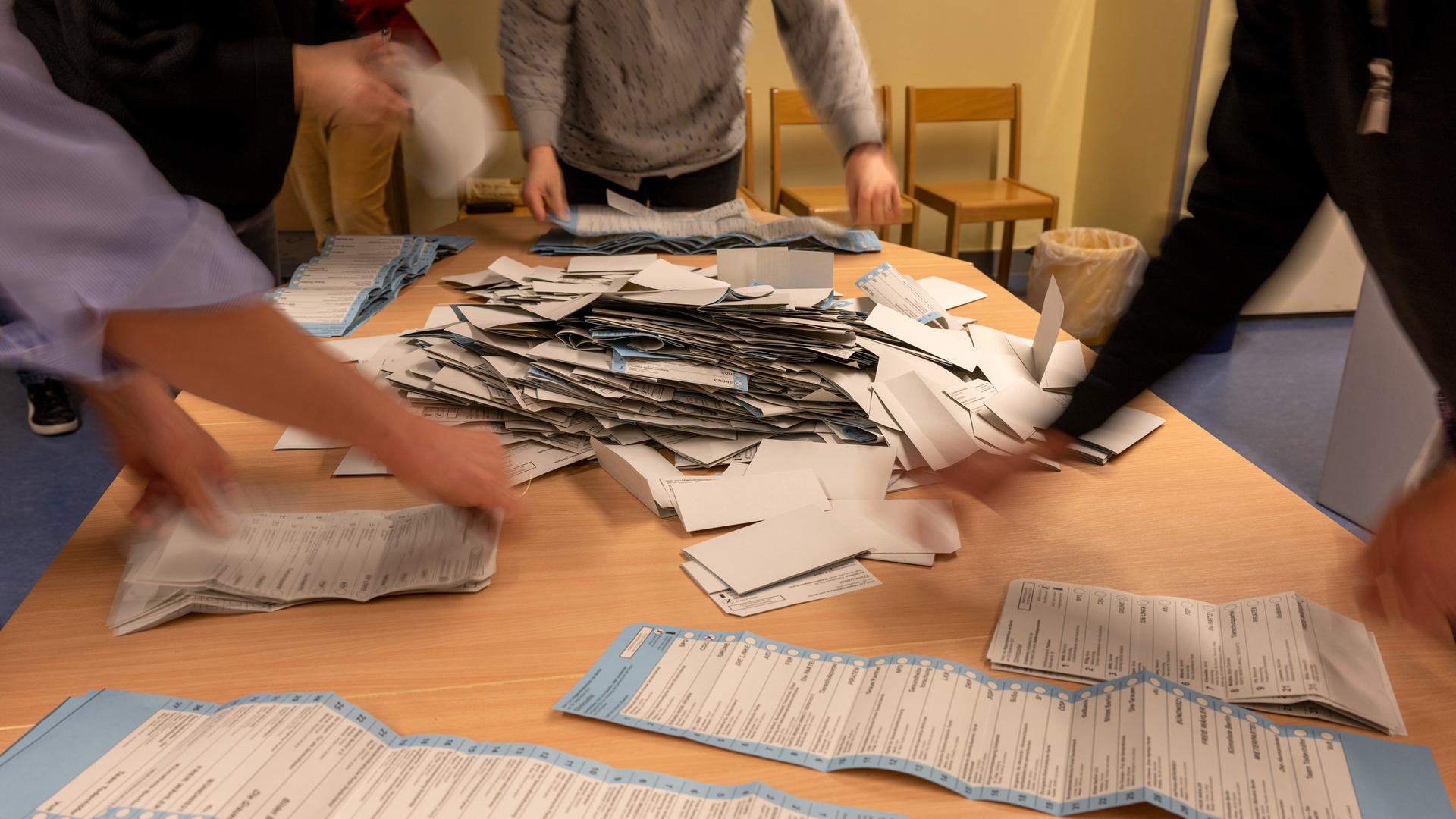 Wahlhelfer sortieren nach der wiederholten Wahl die Stimmzettel in einem Wahllokal in der Grundschule am Teutoburger Platz in Prenzlauer Berg. 