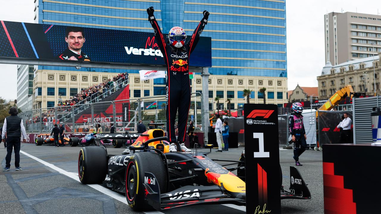 Red Bull-Pilot Max Verstappen steht auf seinem Wagen und streckt die Hände in die Höhe.