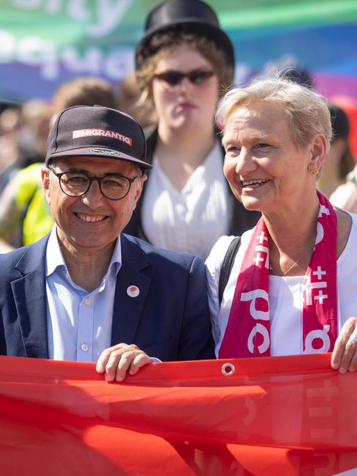 Die Vorsitzende des Rates der Evangelischen Kirche in Deutschland (EKD), Kirsten Fehrs, hält auf einer Kundgebung am 1.Mai 2025 mit anderen Vertretern aus Gewerkschaften, Kirche und Politik ein rotes Banner fest.