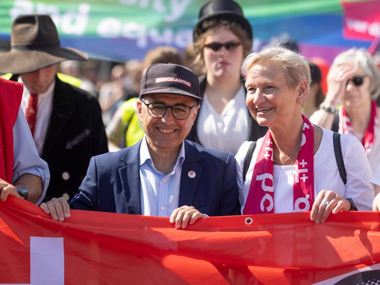 Die Vorsitzende des Rates der Evangelischen Kirche in Deutschland (EKD), Kirsten Fehrs, hält auf einer Kundgebung am 1.Mai 2025 mit anderen Vertretern aus Gewerkschaften, Kirche und Politik ein rotes Banner fest.