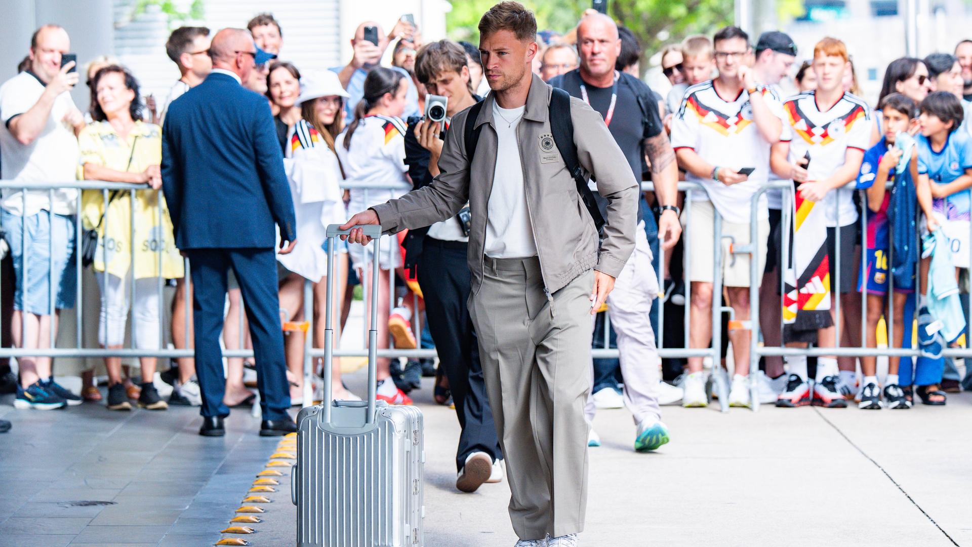 Joshua Kimmich kommt mit einem Rollkoffer am Team-Hotel der deutschen Mannschaft in Houston an, im Hintergrund Fans im DFB-Trikot. Joshua Kimmich kommt mit einem Rollkoffer am Team-Hotel der deutschen Mannschaft in Houston an, im Hintergrund Fans im DFB-Trikot.