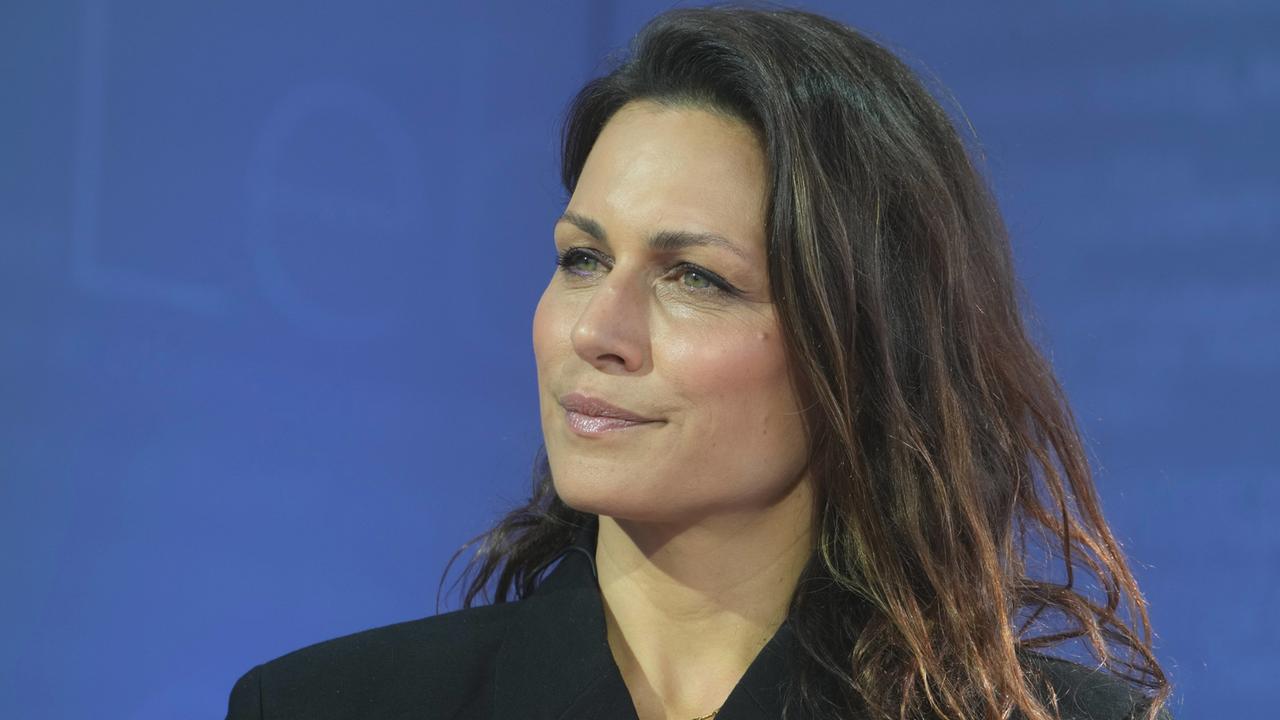 Porträt der Publizistin Shila Behjat vor blauem Hintergrund.