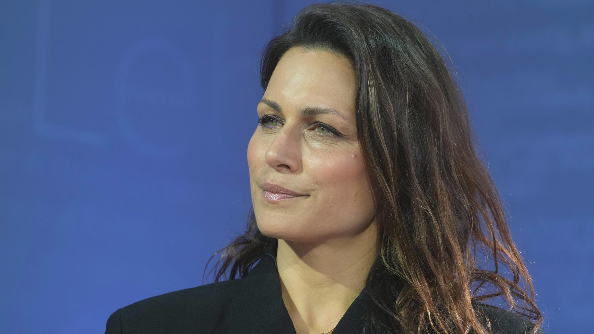 Porträt der Publizistin Shila Behjat vor blauem Hintergrund.