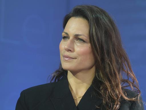 Porträt der Publizistin Shila Behjat vor blauem Hintergrund.