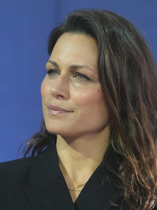 Porträt der Publizistin Shila Behjat vor blauem Hintergrund.