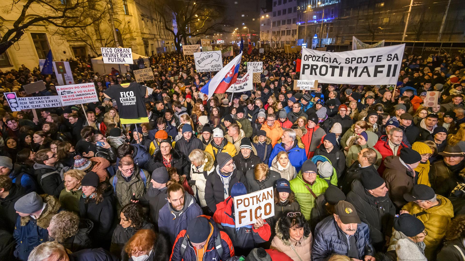 Eine Menschenmenge läuft nach Eibruch der Dunkelheit mit Plakaten und Spruchbändern durch die slowakische Hauptstadt Bratislava.